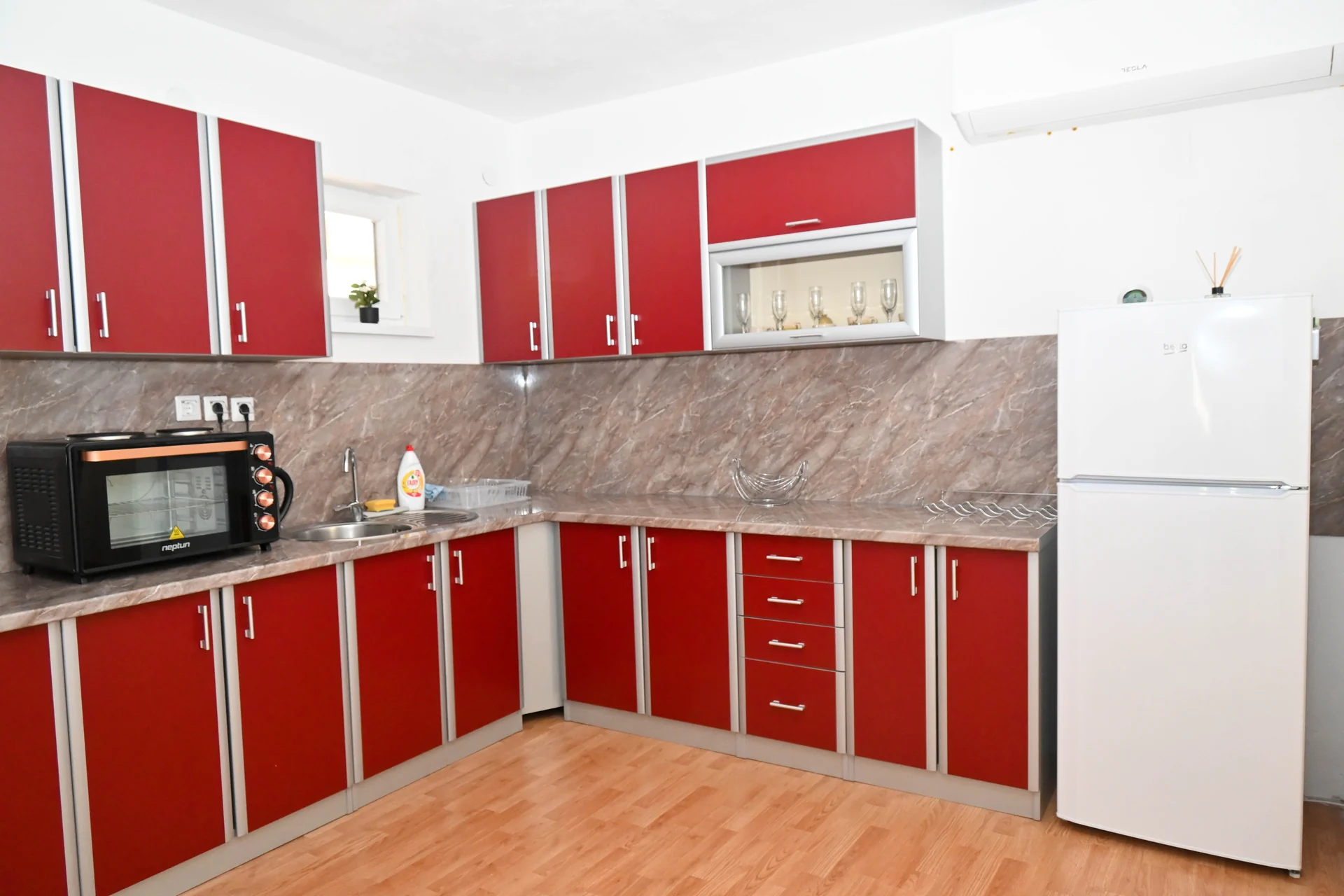 Riverside: rote Küche mit Backofen und Kühlschrank