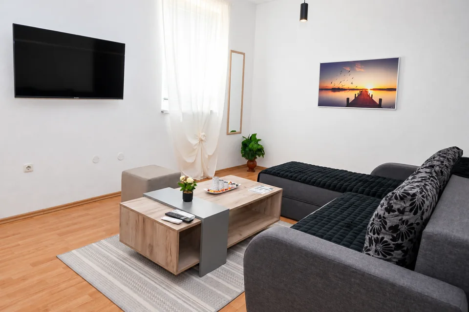 Riverside: Wohnbereich mit großem grauem Sofa und Couchtisch
